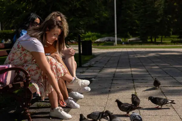 Photo of A woman gives popcorn to a pigeon.