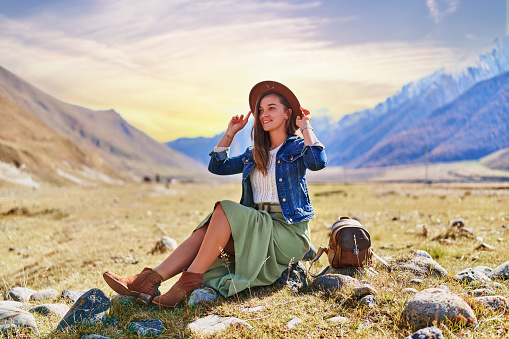Portrait of a hipster young cute attractive smiling girl traveler travelling in mountain valley