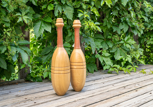 High angle view of two red wineglasses shot on rustic wooden table.  A box with two new wine bottles, straw, a corkscrew with a cork and grapes complete the composition. Predominant colors are red and brown. High resolution 42Mp studio digital capture taken with SONY A7rII and Zeiss Batis 40mm F2.0 CF lens