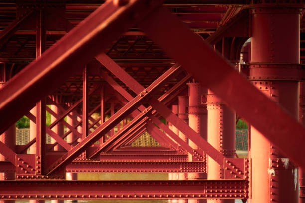 Red iron bridge piers over the river and a consecutive triangles