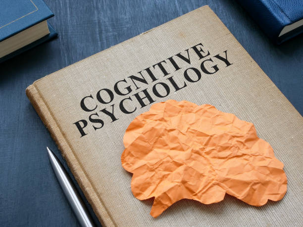 istock Cognitive psychology book and paper brain on it. 1499779055