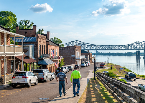 Natchez, MS, USA. 7 June 2023. Two men walking towards water front in Natchez with the Mississippi River