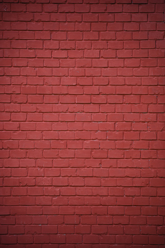 Dark red facade of old building with green shutters.