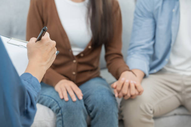 istock Couple hold hand support each while discussing family issues with psychiatrist. Husband encourages and empathy wife suffers depression. psychological, save divorce, Hand in hand together, trust, care 1499783399