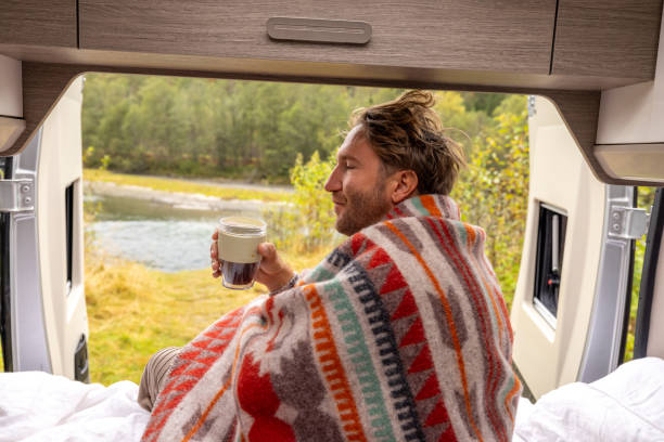 istock Young man wakes up in his camper van, he looks outside 1499785455