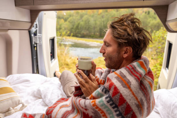 istock Young man wakes up in his camper van, he looks outside 1499785457