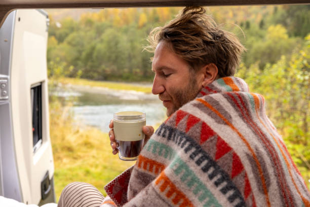 istock Young man wakes up in his camper van, he looks outside 1499785530