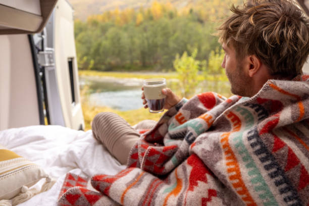 istock Young man wakes up in his camper van, he looks outside 1499785534