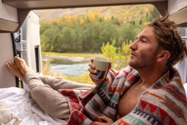 istock Young man wakes up in his camper van, he looks outside 1499785540