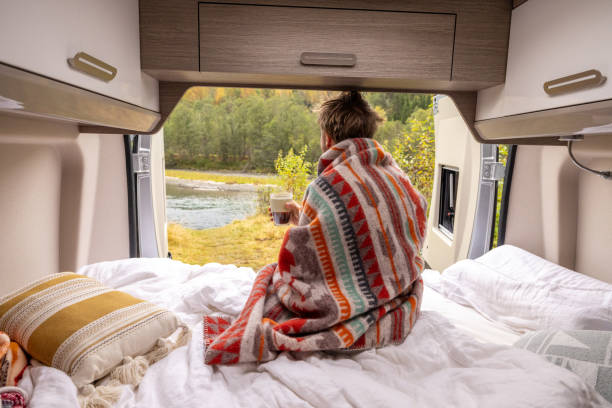 istock Young man wakes up in his camper van, he looks outside 1499785579