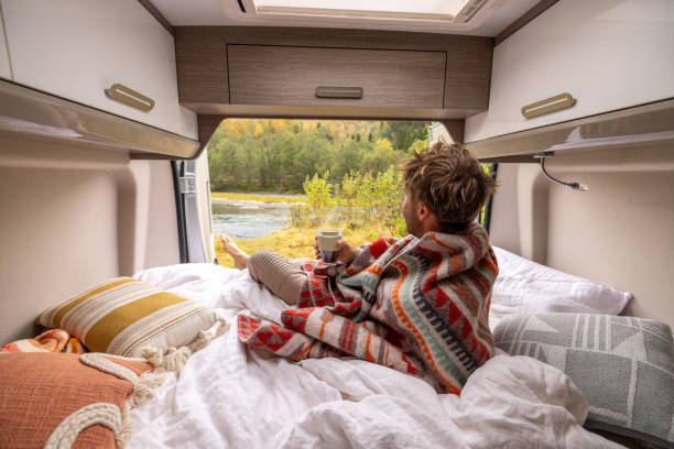istock Young man wakes up in his camper van, he looks outside 1499785581
