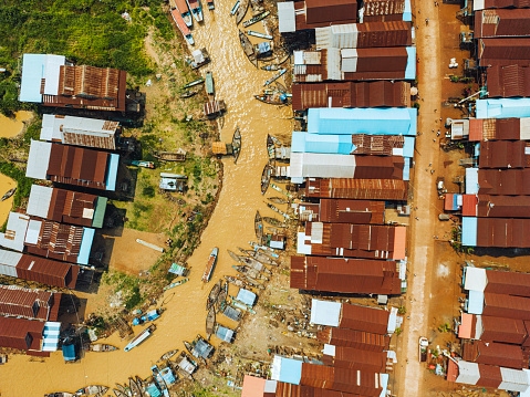 Stilt houses and fishing boats in Kampong Phluk, a floating village near Siem Reap, Cambodia. Aerial drone view.