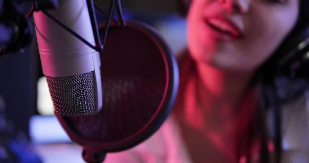 istock Musical Concept. Close up studio condenser microphone. Anti-vibration mount live recording with color lights. Microphone in a recording studio 1499788342