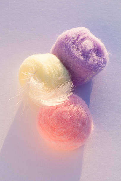 istock Pastel Corored Cotton Balls And Feather At Sunset 149978862