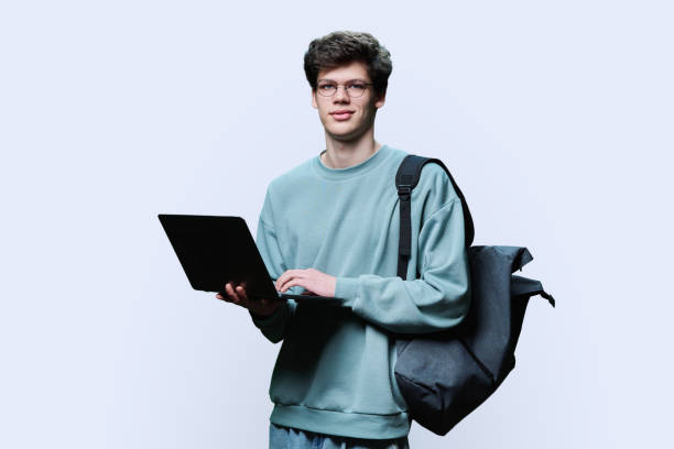 joven estudiante universitario usando computadora portátil, fondo de estudio blanco - vertical caucasian glasses red hair fotografías e imágenes de stock