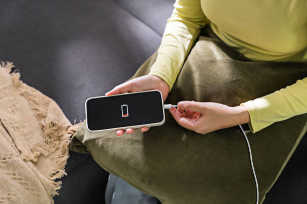 istock Woman hands plugging a charger in a smart phone. Charging Smartphone with Wireless Charging Pad at Home 1499794349