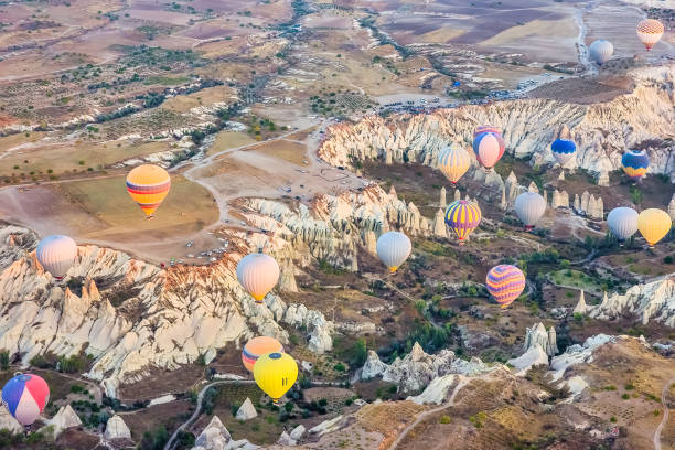 vista aérea de uma frota de balões de ar quente acima do vale do amor, na capadócia, turquia - traditional festival adventure air air vehicle - fotografias e filmes do acervo