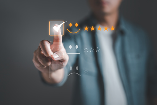 Male customer touching checkmark in checkbox review satisfaction survey on excellent smiley face icon and five star rating in service impressed, feedback for service providers to improve business
