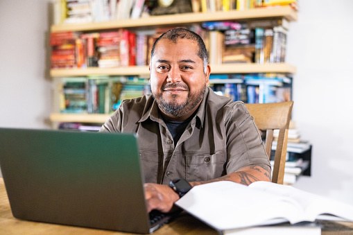 A Hispanic American veteran double amputee on a laptop