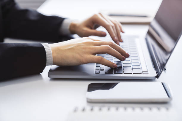 istock With a blurred office environment in the backdrop, the image focuses on a woman's hands typing on a state-of-the-art laptop keyboard 1499801427