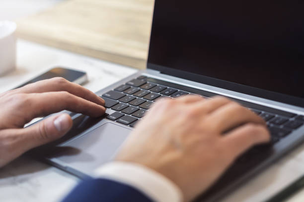 istock With the office setting blurred in the backdrop, the image shows a close-up of a man's hands typing on a contemporary laptop 1499801670