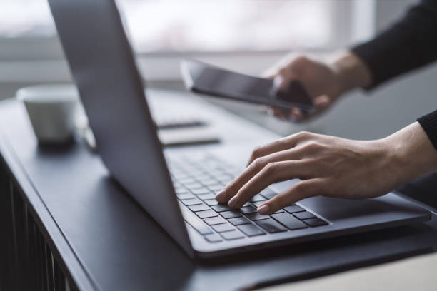 istock A close observation of a woman's hands actively typing on a sleek laptop keyboard, set against a fuzzy office backdrop 1499802033