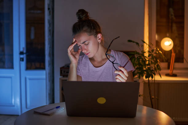 istock Tired stressed woman workaholic holding eyeglasses and suffering from headache while sedentary late computer work at home 1499804838