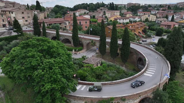 Vintage cars on the historic bridge of San Quirico D'Orcia in Tuscany.