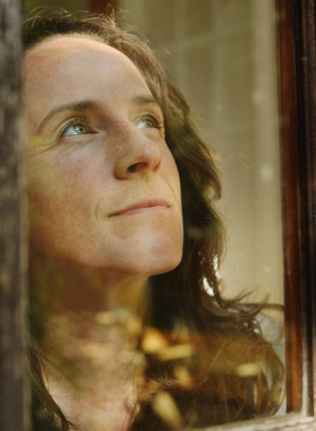 istock Thoughtful woman looking outside the window at home 1499809371