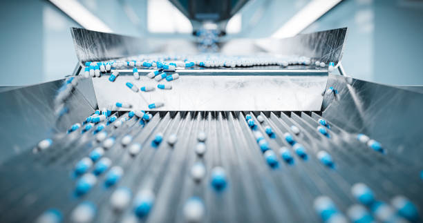 Sorting pharmaceutical capsules by a sorting machine on a production line Sorting pharmaceutical capsules by a sorting machine on a production line labeling stock pictures, royalty-free photos & images