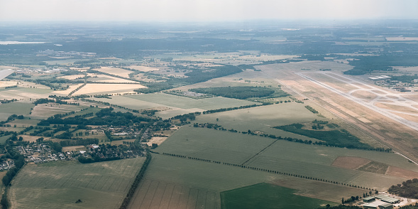 Aerial photography, view on Schönefeld. Brandenburg, Berlin from airplane through the window. Landscape with city and agriculture field from the high point. Traveling concept photo from air.