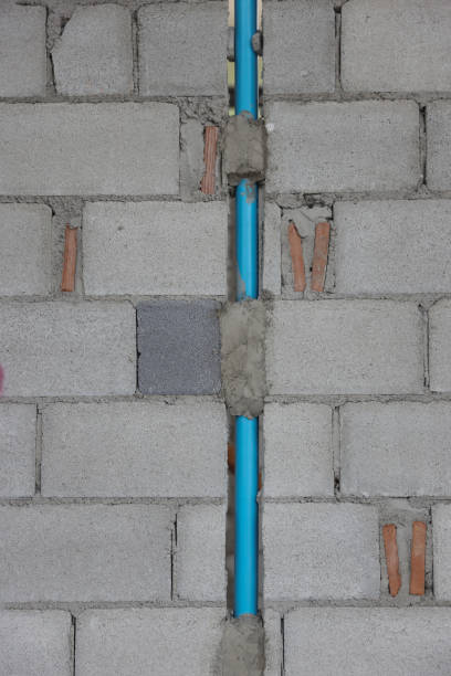 istock Texture background of construction brick wall with PVC pipe, new house construction, Vertical  blue pvc pipe on gray wall background . 1499816839