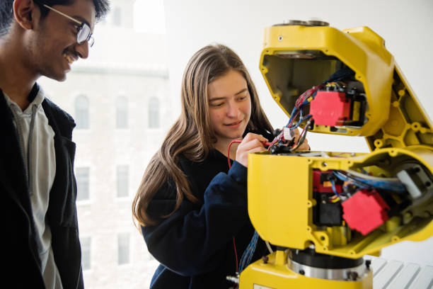 istock Team of college students in robotics classroom. 1499824584