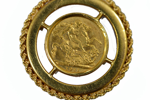 The sovereign is a British gold coin shape with a nominal value of one pound sterling, a bullion coin and is sometimes mounted in Jewellery with the design of George and the Dragon on the reverse, selective focus