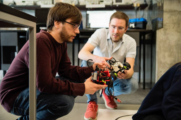 istock Professor and college student in robotics classroom. 1499824725