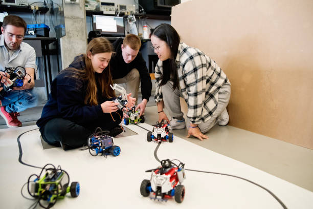 istock Diverse team of college students and professor in robotics classroom. 1499825014