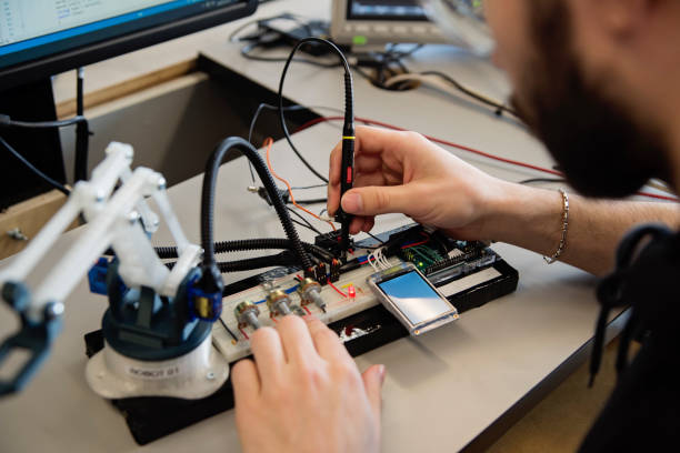 Close-up on hands of college student in robotics classroom. He is working on an electronic device. Horizontal close-up indoors shoot with copy space. STEM topic. No face. This was taken in Quebec, Canada.