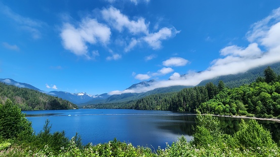 Beautiful snow covered mountain peak view of the Two Lions with calm blue water at front, on a sunny day