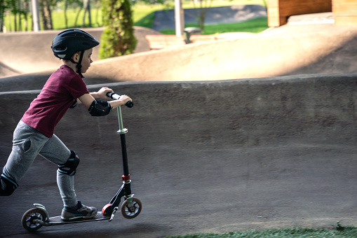 Boy riding push scooter at the track