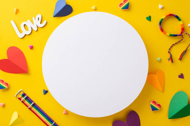 istock An empty circle for text or advertising is surrounded by a top view flat lay of Pride-themed accessories, including pins, hearts, rainbow colored bracelet, wristbands, on a vibrant yellow background 1499835301