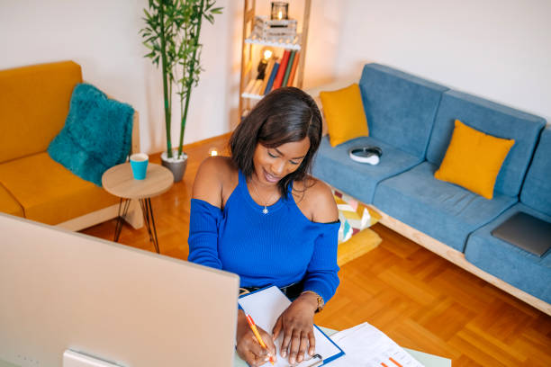 istock Young black woman studying at home and writing something 1499837611
