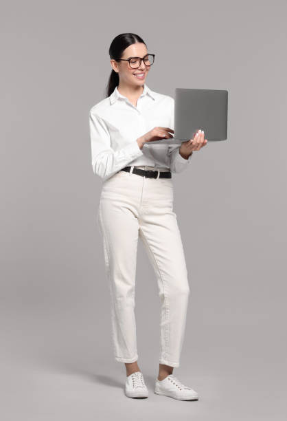 istock Happy woman using laptop on light gray background 1499840450