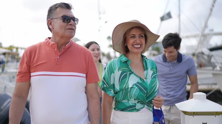 Family arriving to the harbor and entering on a yacht