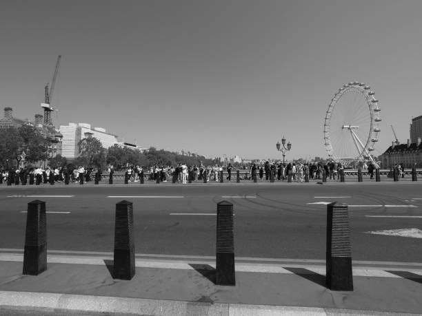 London, UK - June 08, 2023: People on Westminster Bridge over River Thames in black and white