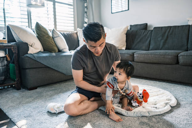 istock Young Korean Father at Home dressing up toddler son 1499851777