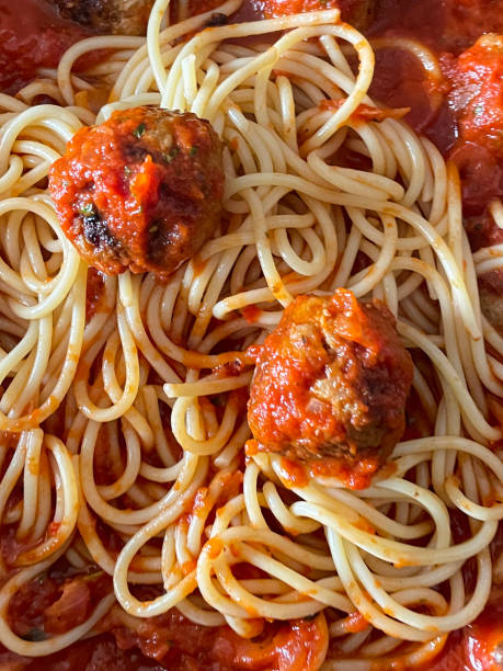 Full frame image of cooked meatballs with freshly cooked spaghetti pasta and tomato ragu sauce, homemade pork balls, elevated view