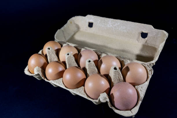 istock Studio shot of an isolated eggs box on a black background containing brown eggs, ra and organic, ready to be cooked. 1499860566