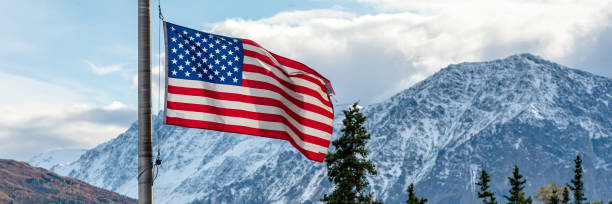 istock American flag with snow capped mountains background in Alaska. 1499861993