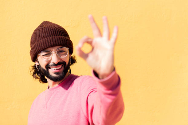 istock man doing ok sign with hand in a yellow background 1499868059
