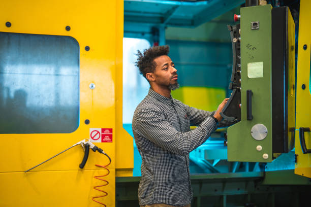 istock Black Mid Adult Male CNC Operator Pressing Buttons 1499869391